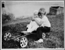 Du vaikai žaislinės mašinėlės ratuose